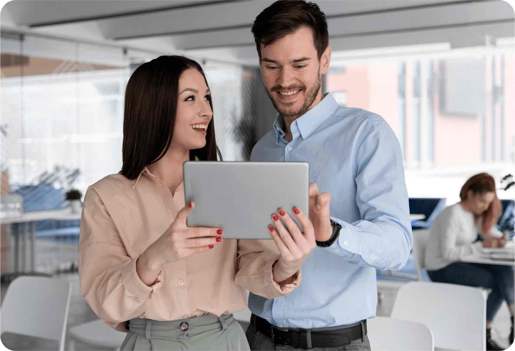 Dos empelados miran sonrientes una tablet