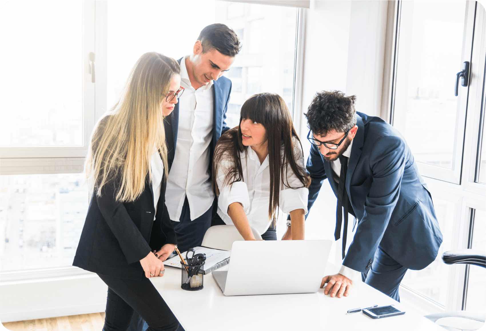 Varios empleados revisan un portatil