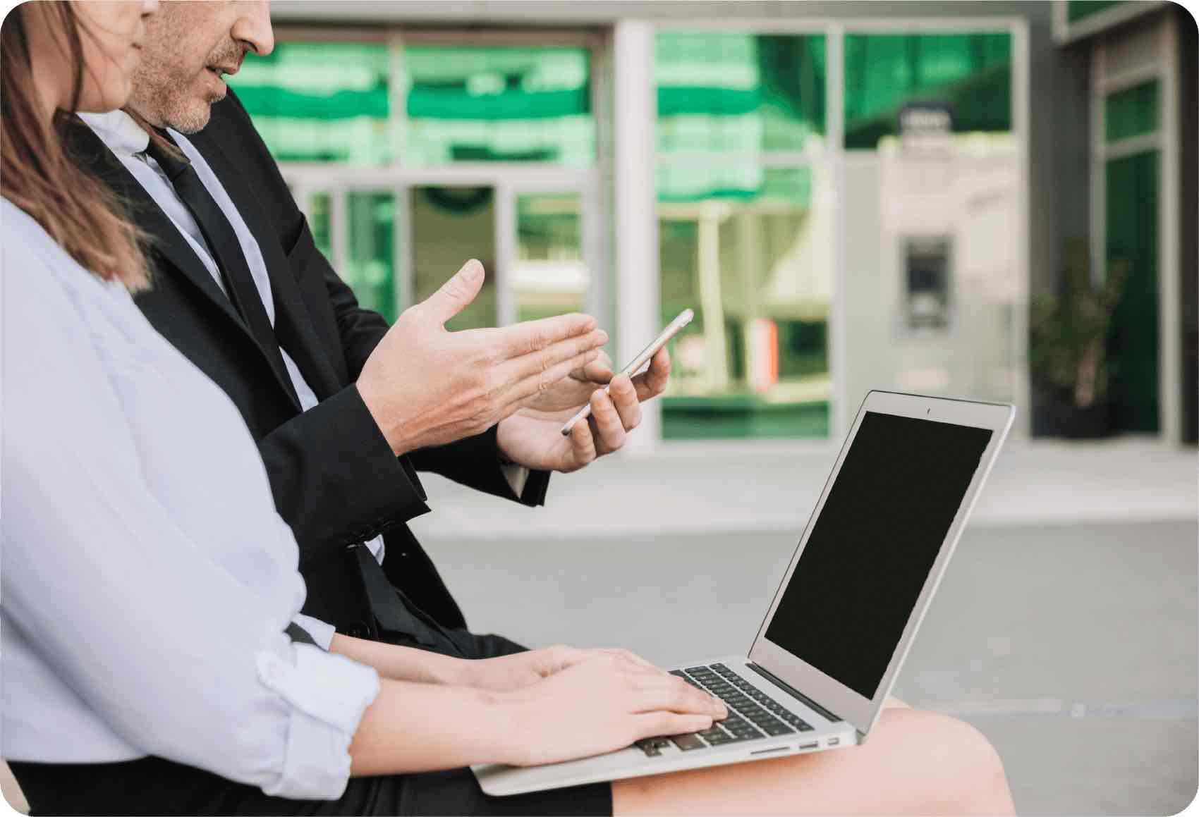 Empleados revisando un móvil y un portatil